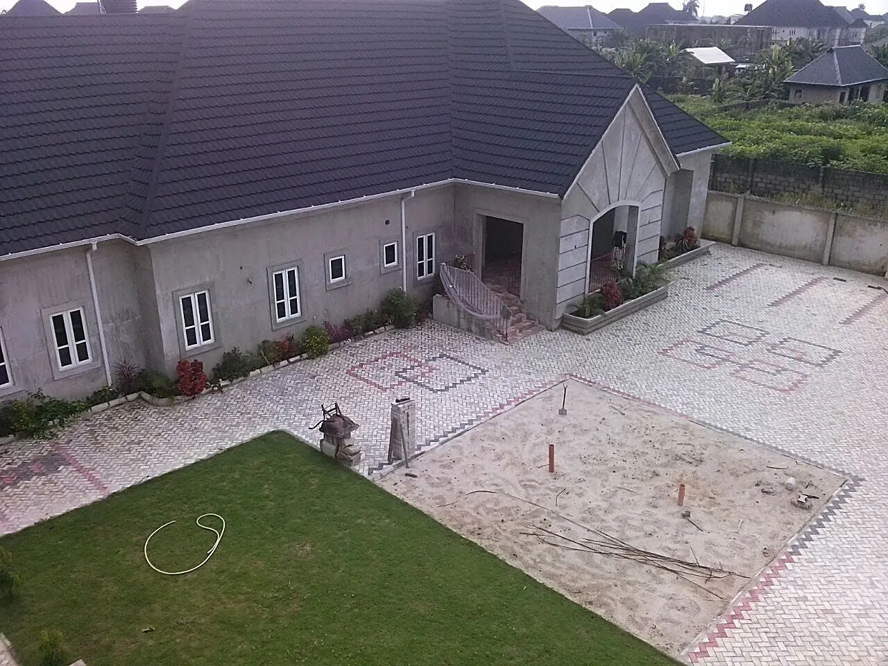 Completed premium residence with stone-coated roof, aerial courtyard view
