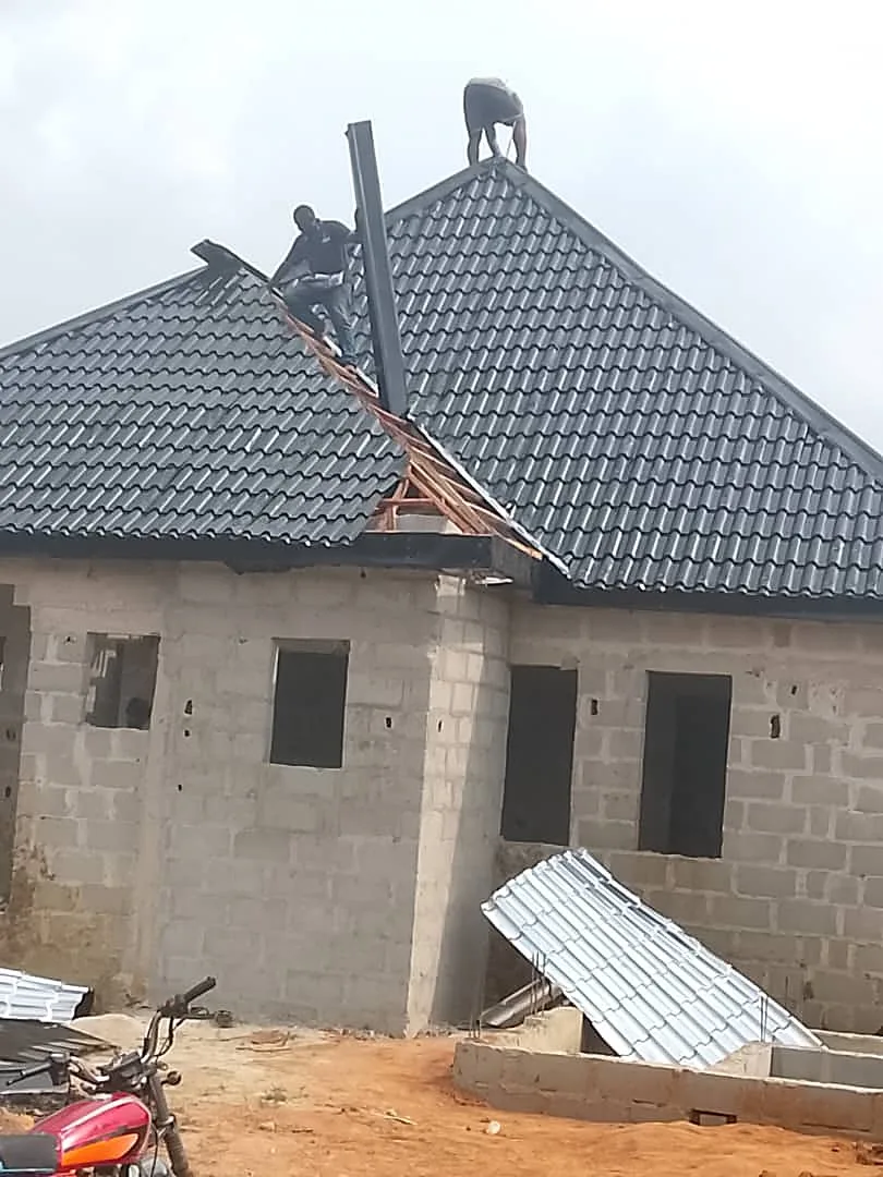 Roofer installing stone-coated tile on duplex
